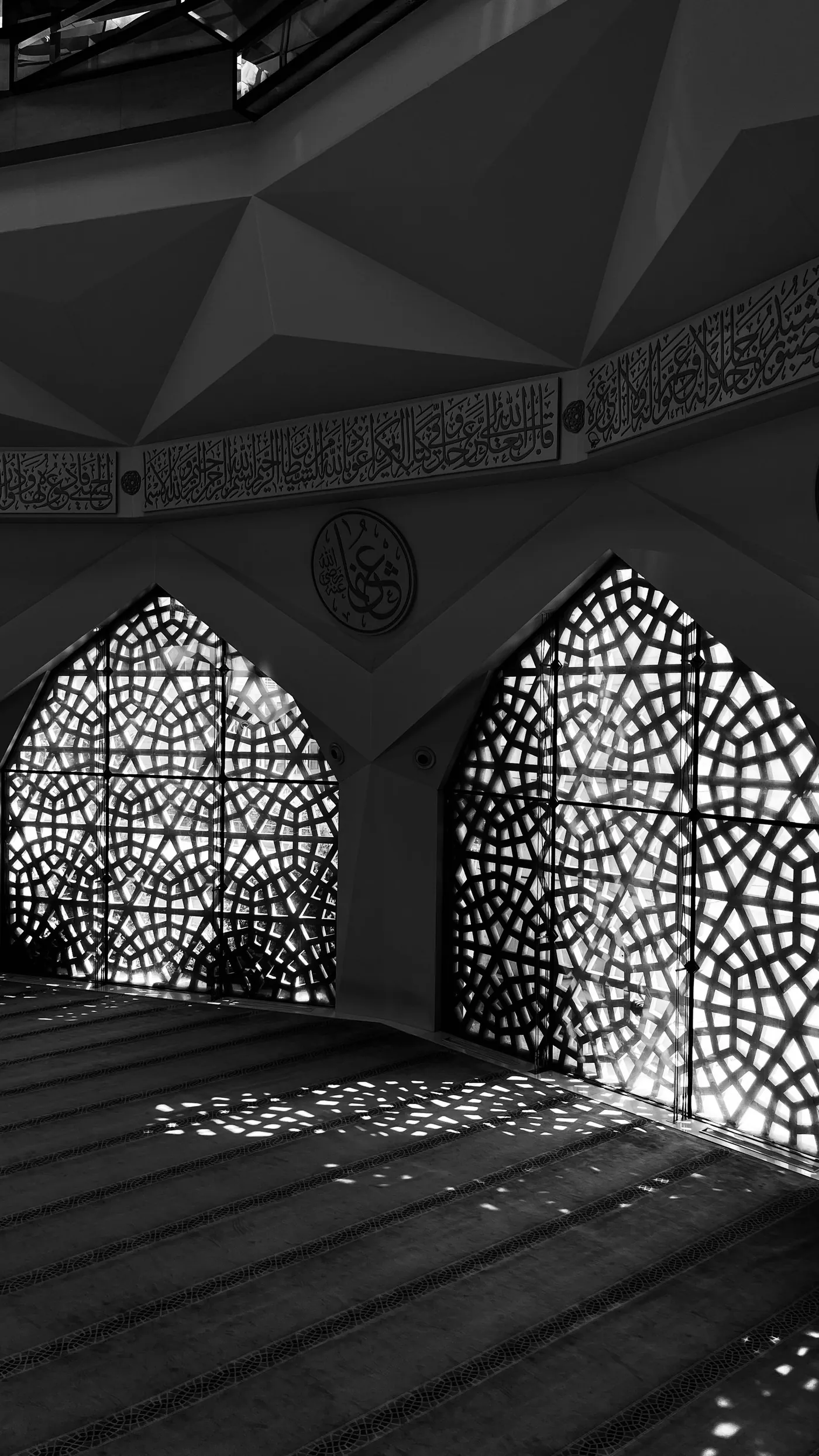 Les ombres d'une fenêtre ajourée projetées sur le sol d'une mosquée