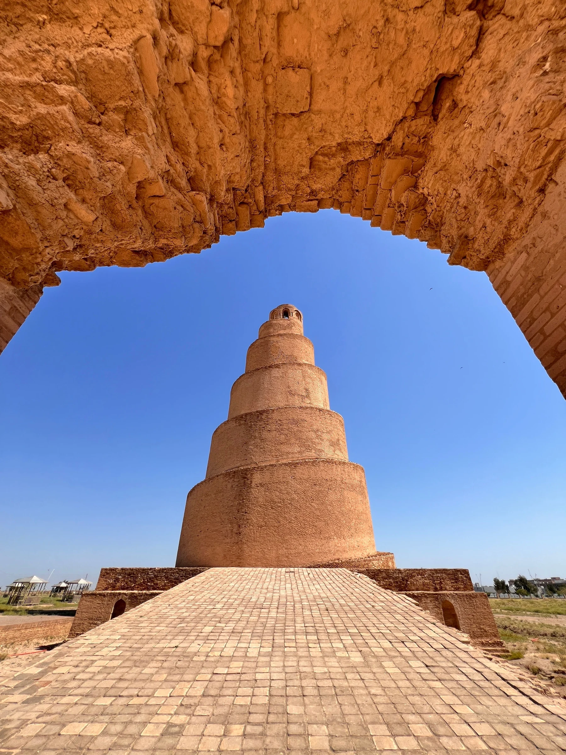 Le minaret Malwiya de Samarra encadré par une arche en ruine de l'enceinte de la mosquée