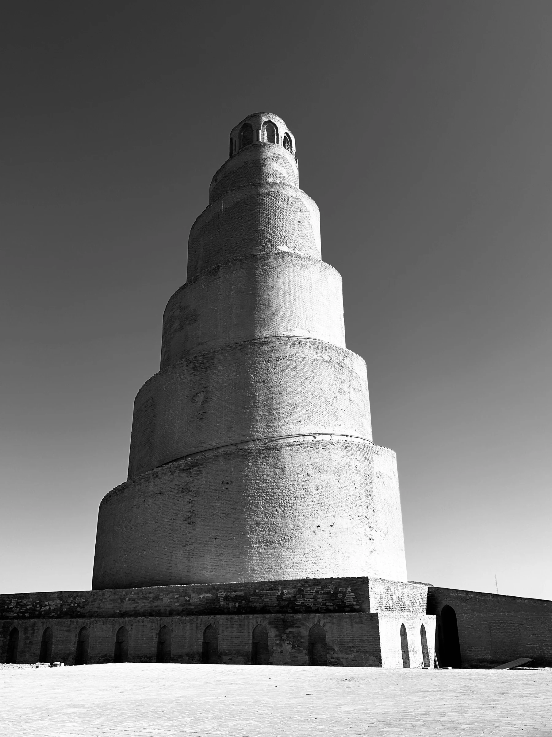 Photographie en noir et blanc du minaret Malwiya de Samarra, soulignant la géométrie conique de la tour