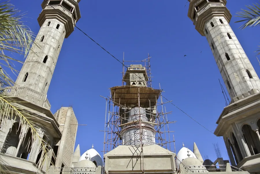 Travaux d'agrandissement d'un minaret de la Grande Mosquée de Touba, échafaudage visible entre deux tours existantes
