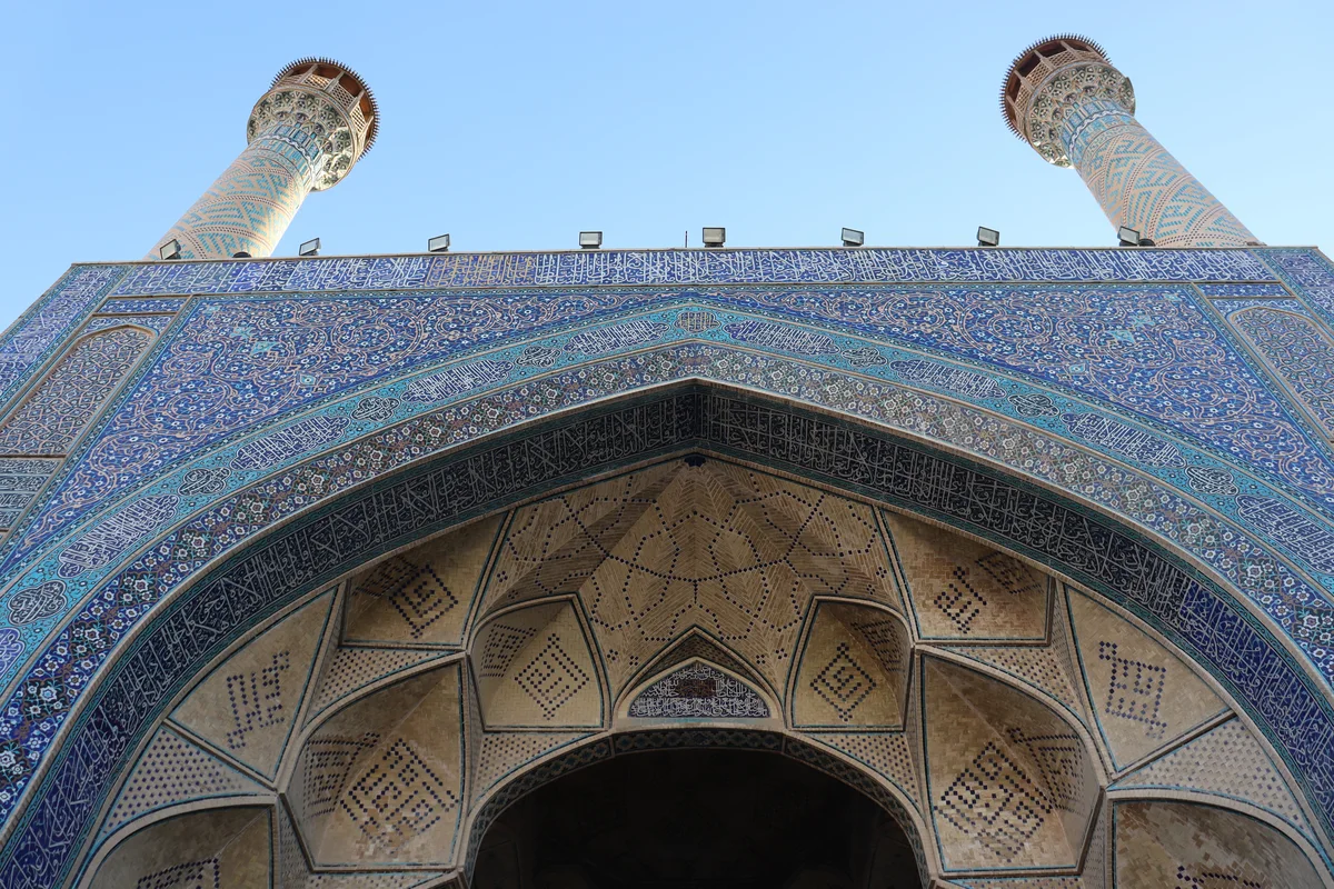Portail principal de la Grande Mosquée du Vendredi d'Ispahan, orné de céramique bleue et flanqué de deux minarets