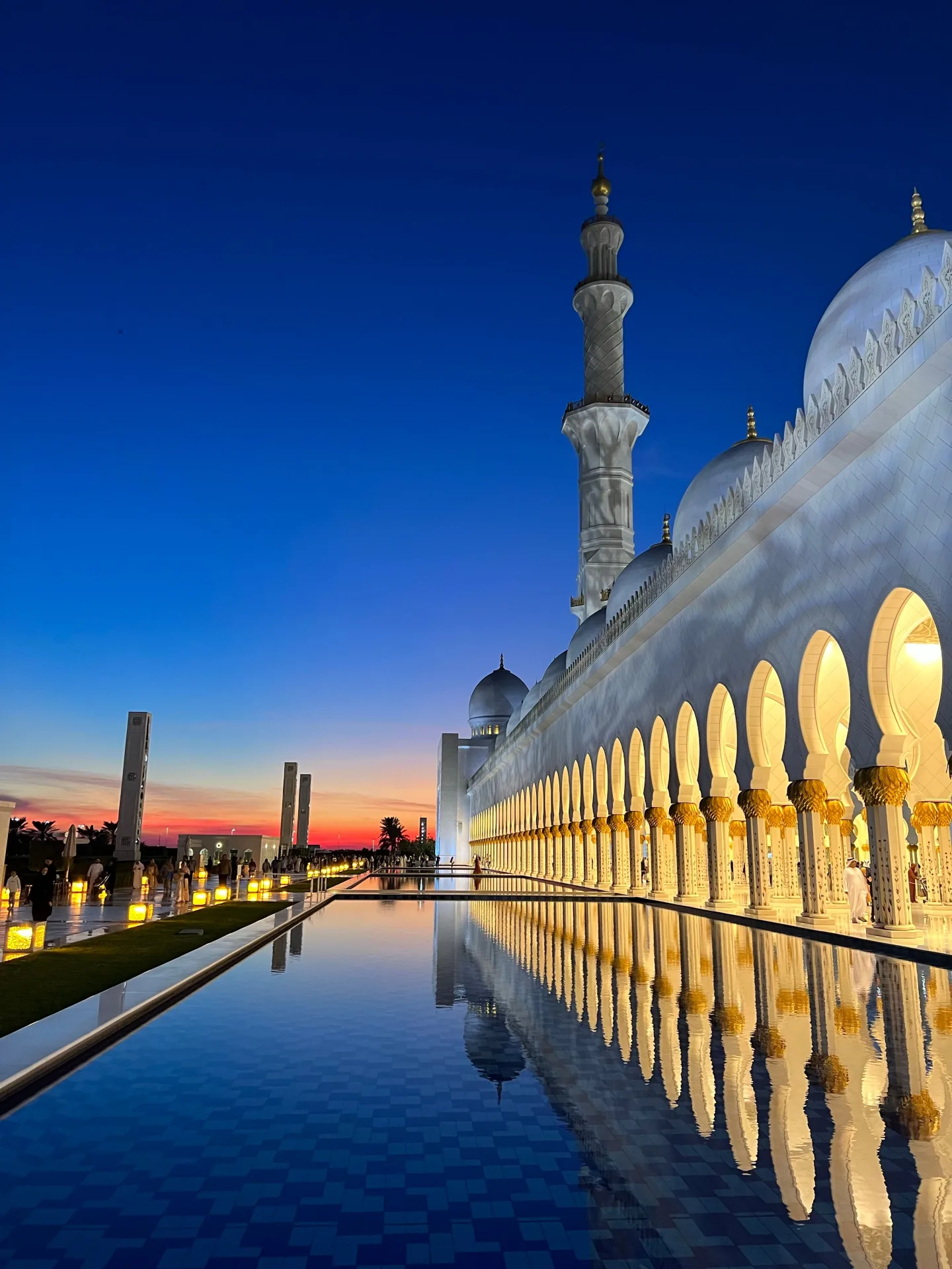 Mosquée Cheikh Zayed à l'heure bleue — Arcades illuminées reflétées dans le bassin