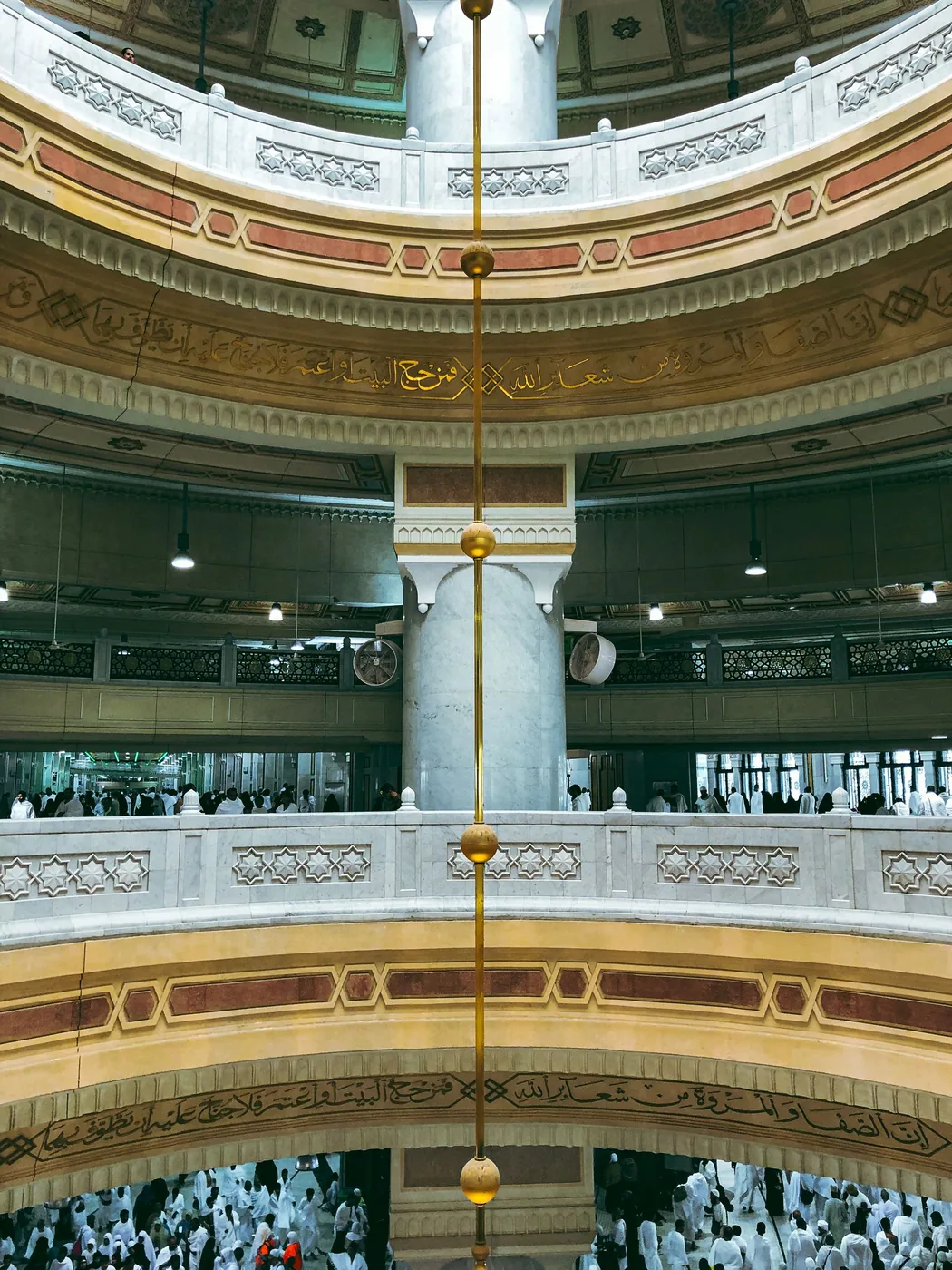 Deux niveaux de galeries superposés, chacun rempli de fidèles