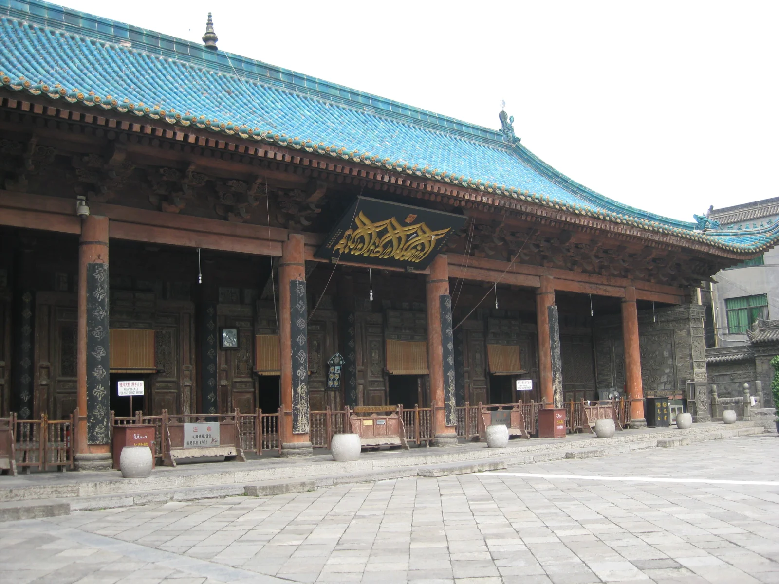 Grande Mosquée de Xi'an — entrée de la salle de prière, calligraphie arabe dorée au-dessus des colonnes de bois